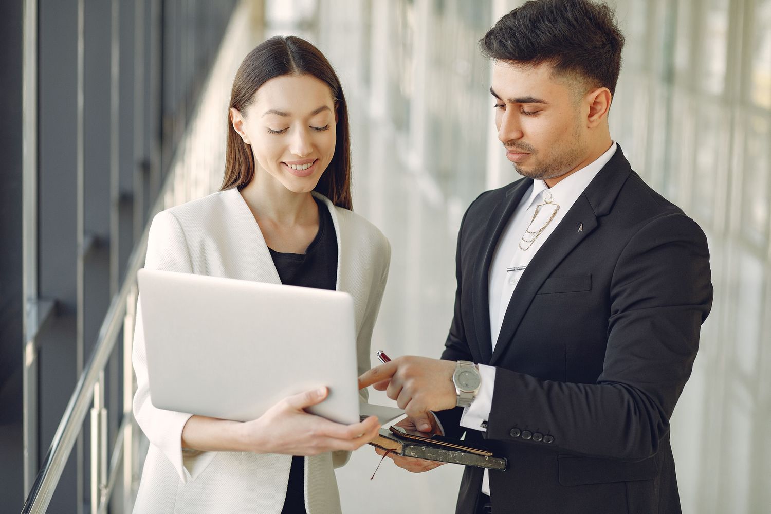 Two colleagues reviewing a laptop